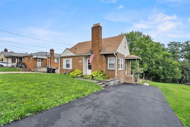 110 5th Ave, Ross Twp, PA 15229 - bungalow-style home with brick siding, a front lawn, a chimney, asphalt driveway, and roof with shingles