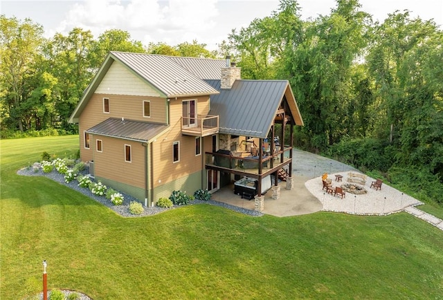 2780 Ipnar Rd, North Huntingdon, PA 15642 - back of property with an outdoor fire pit, a standing seam roof, a patio area, a chimney, and a metal roof