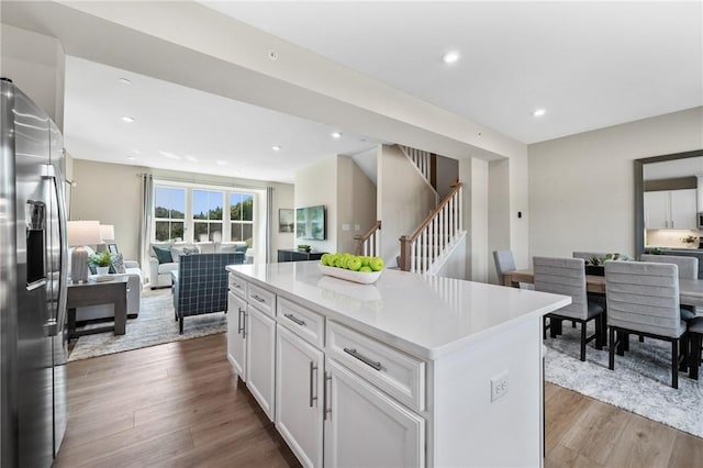214 Hunter Dr, Moon/Crescent Twp, PA 15108 - kitchen featuring stainless steel fridge, open floor plan, white cabinetry, wood finished floors, and a kitchen island