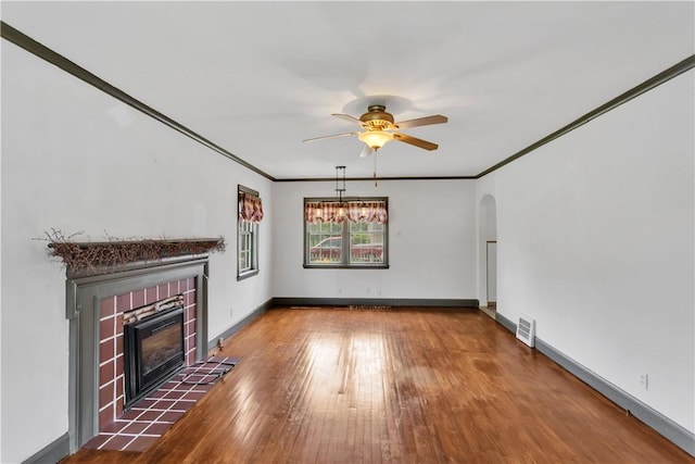1255 Park Pl, Beaver, PA 15009 - unfurnished living room featuring ceiling fan, a tile fireplace, hardwood / wood-style floors, arched walkways, and ornamental molding