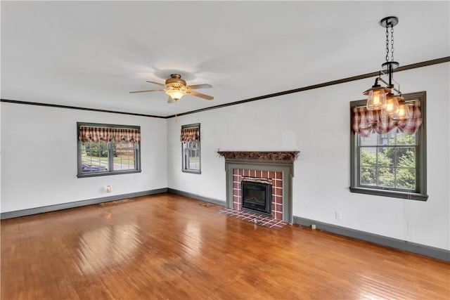 1255 Park Pl, Beaver, PA 15009 - unfurnished living room featuring healthy amount of natural light, a ceiling fan, wood finished floors, crown molding, and a fireplace with flush hearth
