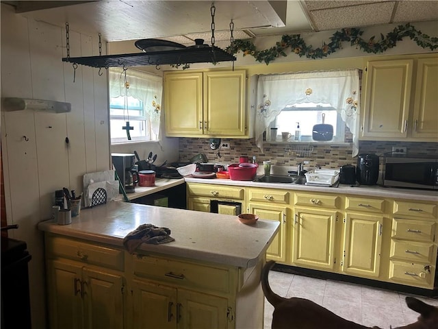 1175 New Salem Rd, Menallen Twp, PA 15468 - kitchen with stainless steel microwave, light countertops, light tile patterned floors, tasteful backsplash, and a peninsula