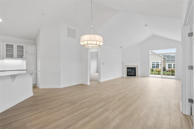 1082 Forest Oaks Dr, Center Twp, PA 16001 - unfurnished living room featuring high vaulted ceiling, light wood finished floors, and a glass covered fireplace