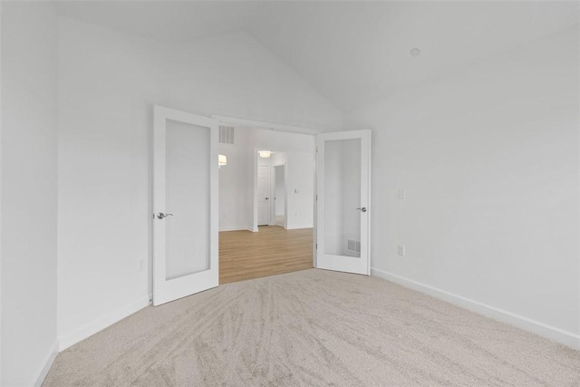 1082 Forest Oaks Dr, Center Twp, PA 16001 - unfurnished bedroom featuring carpet floors, french doors, and vaulted ceiling