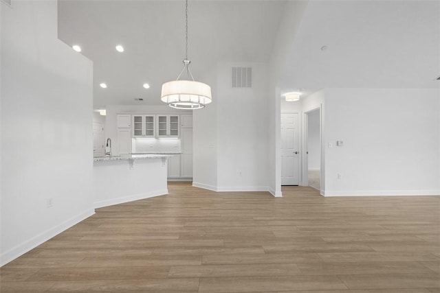 1082 Forest Oaks Dr, Center Twp, PA 16001 - unfurnished living room featuring light wood-style flooring, recessed lighting, and a high ceiling