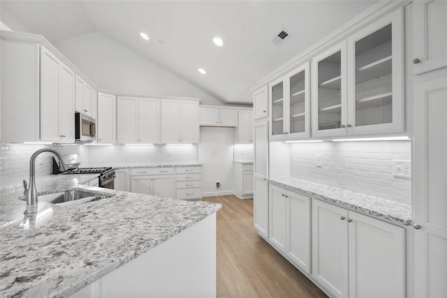1082 Forest Oaks Dr, Center Twp, PA 16001 - kitchen with stainless steel appliances, light stone countertops, glass insert cabinets, lofted ceiling, and decorative backsplash