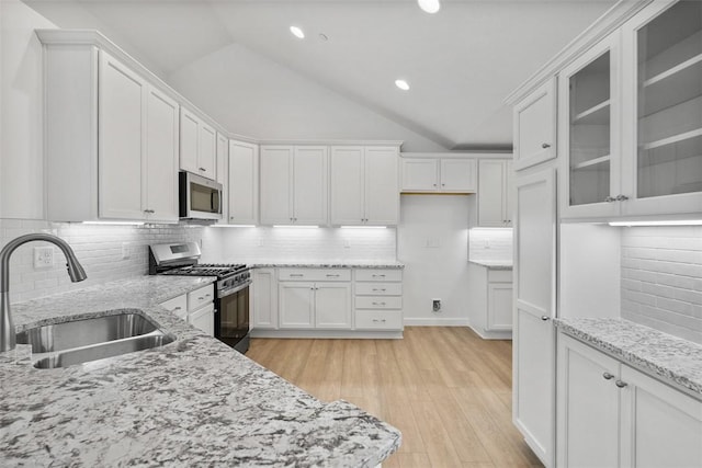 1082 Forest Oaks Dr, Center Twp, PA 16001 - kitchen featuring appliances with stainless steel finishes, vaulted ceiling, white cabinets, light stone counters, and tasteful backsplash