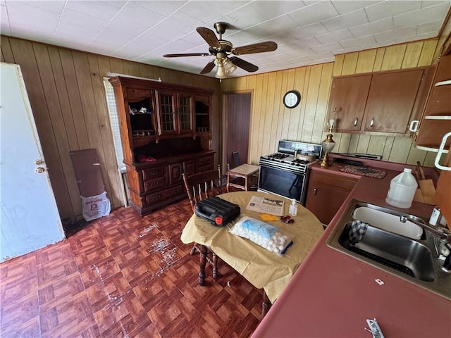 69 Beech St, Cecil, PA 15350 - kitchen with white gas range oven, wooden walls, and ceiling fan