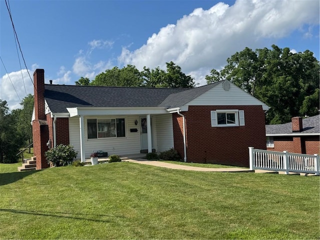 118 Manchester Dr, Hempfield Twp, PA 15642 - view of front facade with a chimney, a front lawn, and brick siding