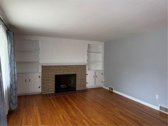118 Manchester Dr, Hempfield Twp, PA 15642 - unfurnished living room featuring a brick fireplace, wood finished floors, and built in features
