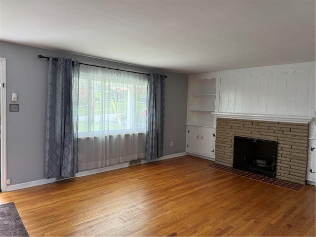 118 Manchester Dr, Hempfield Twp, PA 15642 - unfurnished living room with light wood finished floors and a fireplace with flush hearth