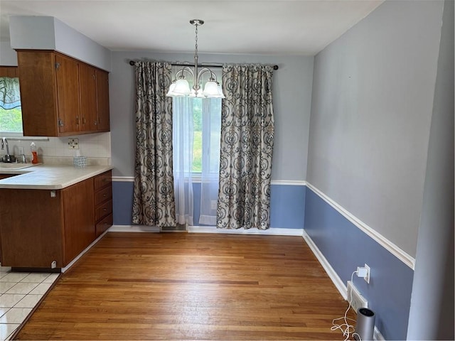 118 Manchester Dr, Hempfield Twp, PA 15642 - unfurnished dining area featuring a chandelier, healthy amount of natural light, and light wood-style floors