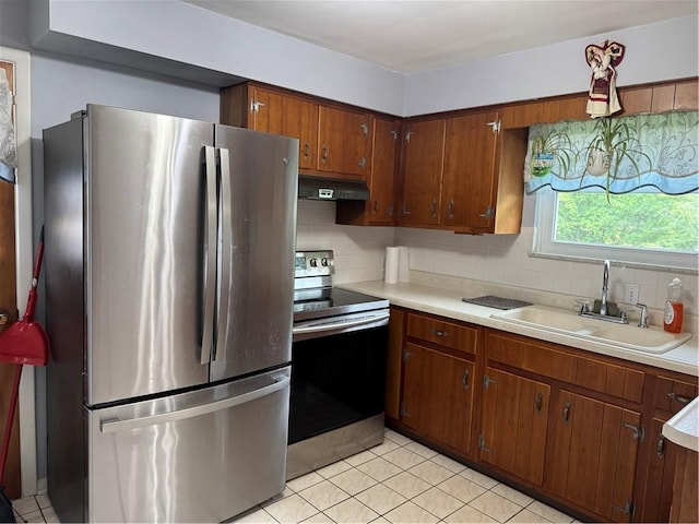 118 Manchester Dr, Hempfield Twp, PA 15642 - kitchen featuring appliances with stainless steel finishes, under cabinet range hood, light countertops, decorative backsplash, and light tile patterned flooring