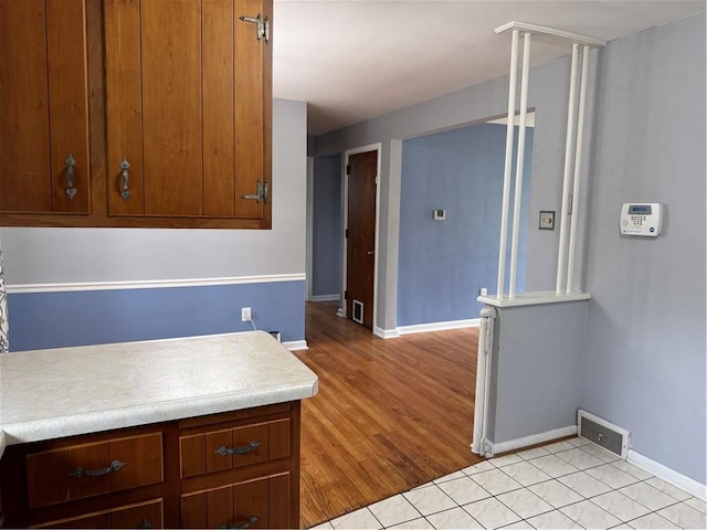118 Manchester Dr, Hempfield Twp, PA 15642 - kitchen with light countertops, brown cabinetry, and light tile patterned floors