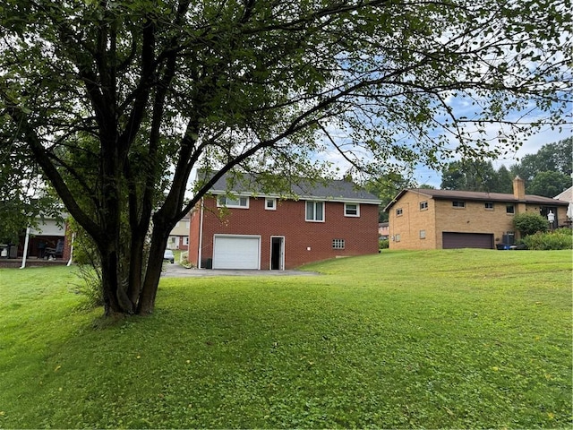 118 Manchester Dr, Hempfield Twp, PA 15642 - view of side of home featuring a garage, driveway, brick siding, and a yard