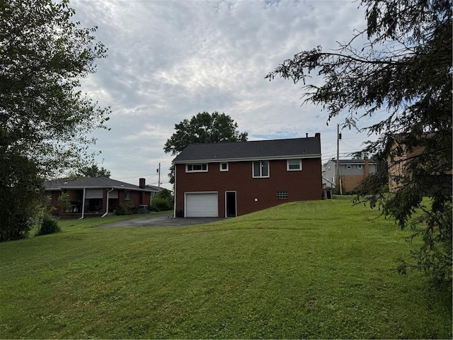 118 Manchester Dr, Hempfield Twp, PA 15642 - back of house with asphalt driveway, an attached garage, a yard, and brick siding