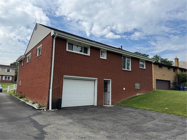 118 Manchester Dr, Hempfield Twp, PA 15642 - view of property exterior with brick siding, a garage, asphalt driveway, and a lawn
