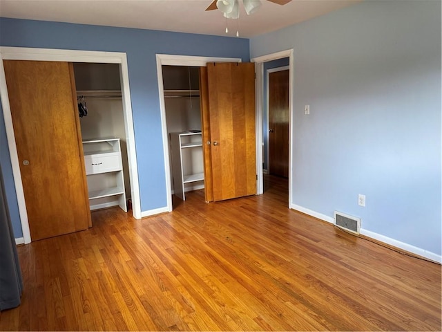 118 Manchester Dr, Hempfield Twp, PA 15642 - unfurnished bedroom with multiple closets, wood finished floors, and a ceiling fan