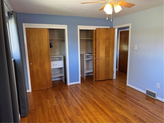 118 Manchester Dr, Hempfield Twp, PA 15642 - unfurnished bedroom with two closets, wood finished floors, and ceiling fan