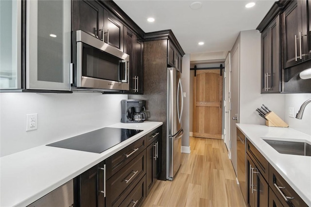 320 Fort Duquesne Blvd Unit 23L, Downtown Pgh, PA 15222 - kitchen featuring appliances with stainless steel finishes, light wood-style flooring, light countertops, a barn door, and recessed lighting