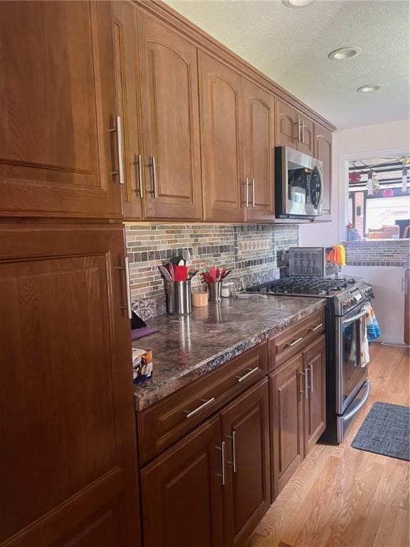 4619 5th Ave, Beaver Falls, PA 15010 - kitchen featuring stainless steel appliances, light wood-style flooring, dark stone countertops, backsplash, and recessed lighting