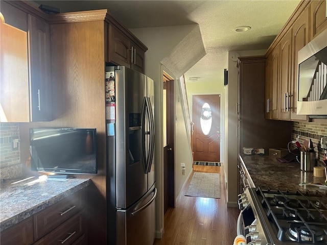 4619 5th Ave, Beaver Falls, PA 15010 - kitchen featuring appliances with stainless steel finishes, tasteful backsplash, dark wood-style floors, and dark countertops