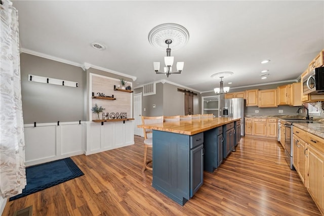 213 Mcdonald Dr, North Huntingdon, PA 15642 - kitchen with stainless steel appliances, a chandelier, ornamental molding, wood finished floors, and light brown cabinetry