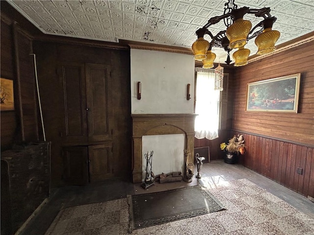 653 Upr Middletown Rd, Menallen Twp, PA 15480 - unfurnished living room with wooden walls, an ornate ceiling, ornamental molding, wood finished floors, and a chandelier