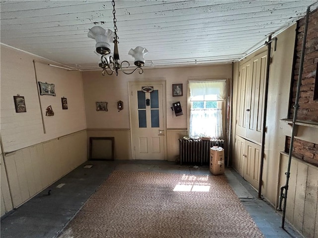 653 Upr Middletown Rd, Menallen Twp, PA 15480 - unfurnished dining area featuring radiator heating unit, wainscoting, a chandelier, and wood walls