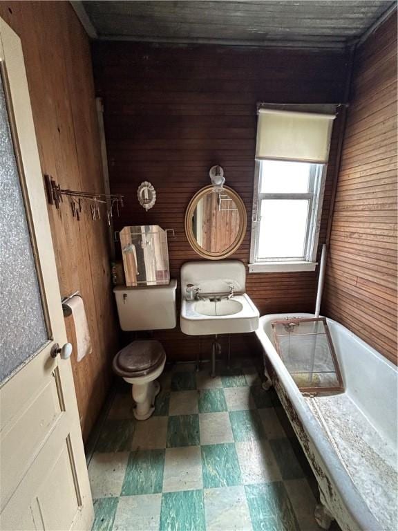 653 Upr Middletown Rd, Menallen Twp, PA 15480 - bathroom featuring wooden walls, tile patterned floors, and a tub to relax in