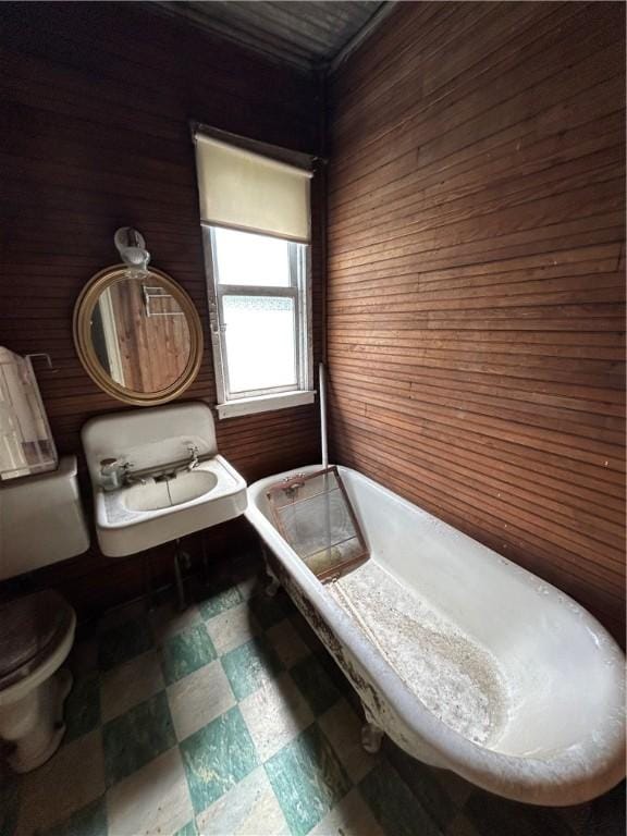653 Upr Middletown Rd, Menallen Twp, PA 15480 - bathroom featuring wooden walls, tile patterned floors, and a freestanding tub
