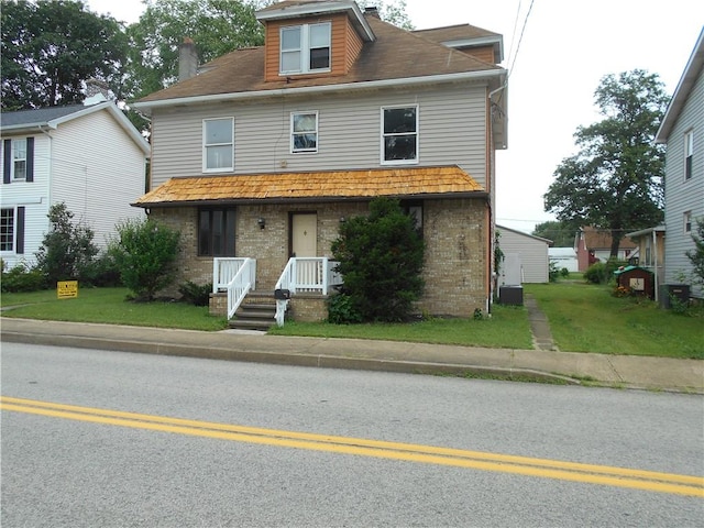 321 E 4th St, Derry Twp, PA 15627 - view of front of house with brick siding, a chimney, covered porch, and a front yard