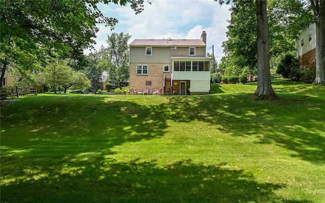 2712 Champlain, Shaler, PA 15101 - rear view of property featuring a sunroom, a chimney, a yard, and stairway