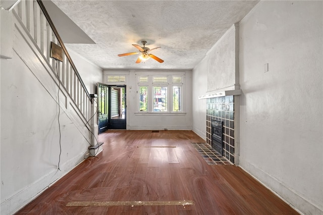 6933 Mcpherson Blvd, Point Breeze, PA 15208 - foyer featuring a tiled fireplace, stairway, wood finished floors, a ceiling fan, and a textured ceiling