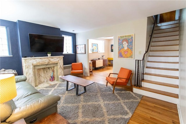 5553 Pocusset St, Squirrel Hill, PA 15217 - living area featuring wood finished floors, stairway, radiator, and a fireplace