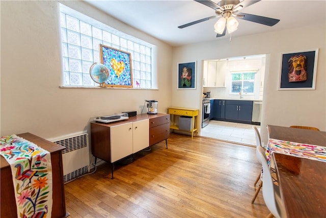 5553 Pocusset St, Squirrel Hill, PA 15217 - bedroom with radiator heating unit, light wood-type flooring, connected bathroom, and ceiling fan