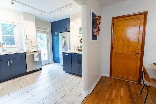 5553 Pocusset St, Squirrel Hill, PA 15217 - kitchen with appliances with stainless steel finishes, blue cabinets, light countertops, and light wood-type flooring