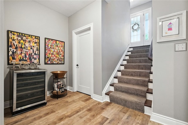 1416 Commons Ln, South Fayette, PA 15017 - stairs with wine cooler, a bar, and wood finished floors