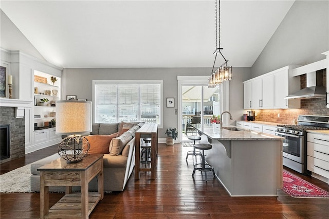 1416 Commons Ln, South Fayette, PA 15017 - kitchen featuring stainless steel gas range oven, wall chimney range hood, vaulted ceiling, backsplash, and white cabinets