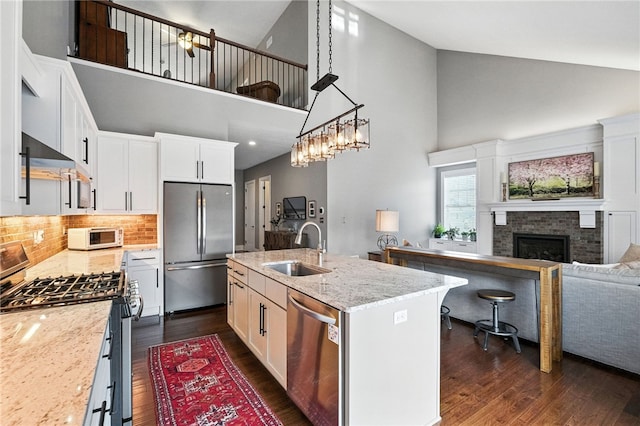 1416 Commons Ln, South Fayette, PA 15017 - kitchen featuring appliances with stainless steel finishes, high vaulted ceiling, dark wood-style floors, a fireplace, and white cabinets