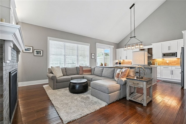 1416 Commons Ln, South Fayette, PA 15017 - living room with a fireplace, dark wood-style flooring, high vaulted ceiling, and a chandelier