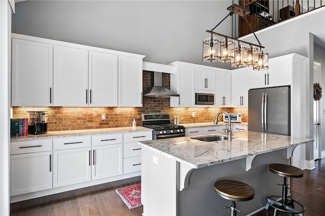 1416 Commons Ln, South Fayette, PA 15017 - kitchen featuring stainless steel appliances, wall chimney range hood, dark wood finished floors, white cabinets, and light stone countertops