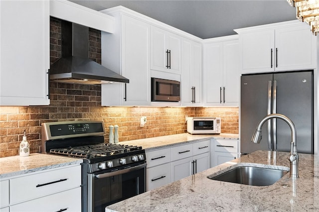 1416 Commons Ln, South Fayette, PA 15017 - kitchen featuring appliances with stainless steel finishes, wall chimney exhaust hood, white cabinets, and light stone counters