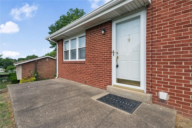 409 Westland Dr, Hempfield Twp, PA 15601 - view of exterior entry featuring brick siding and a patio