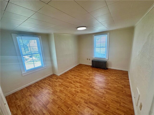1023 Burtner Rd, Harrison Twp, PA 15065 - empty room with radiator heating unit, light wood finished floors, plenty of natural light, and ornamental molding