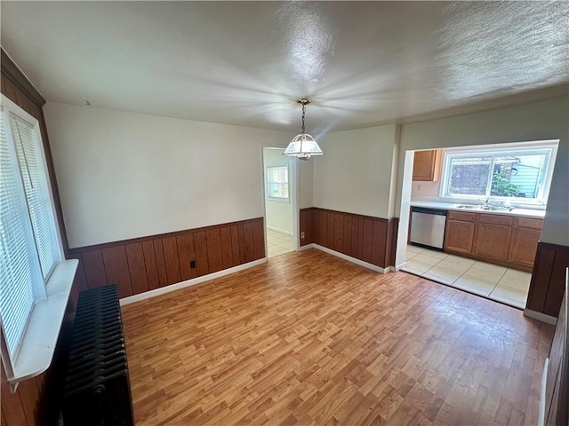 1023 Burtner Rd, Harrison Twp, PA 15065 - unfurnished dining area featuring light wood-type flooring, a wainscoted wall, and wooden walls
