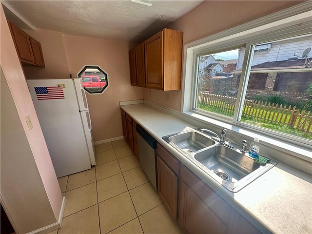 1023 Burtner Rd, Harrison Twp, PA 15065 - kitchen with freestanding refrigerator, dishwasher, brown cabinets, light tile patterned flooring, and light countertops