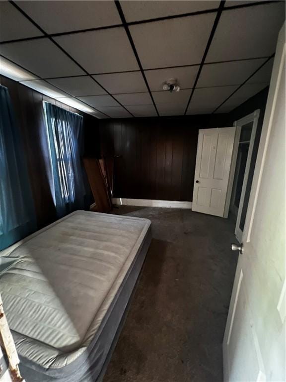 219 Sherman Ave, Vandergrift, PA 15690 - bedroom with wooden walls, concrete floors, and a drop ceiling