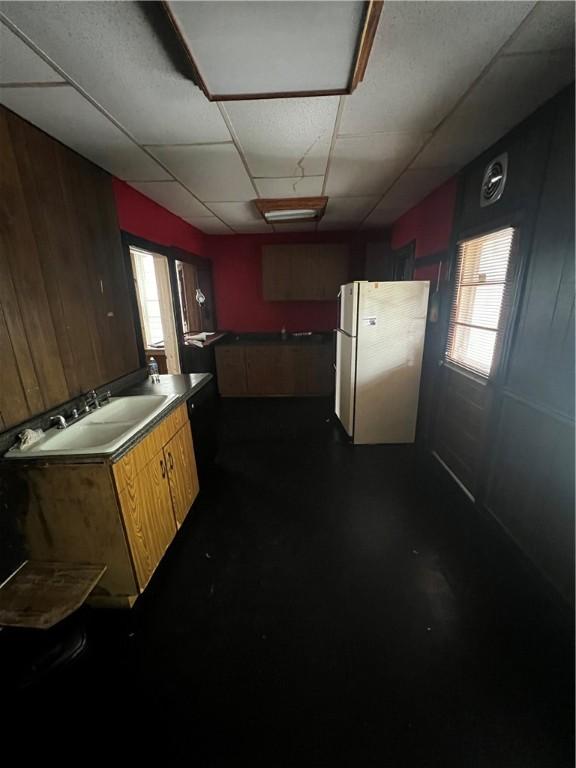 219 Sherman Ave, Vandergrift, PA 15690 - kitchen featuring freestanding refrigerator, a drop ceiling, and wood walls