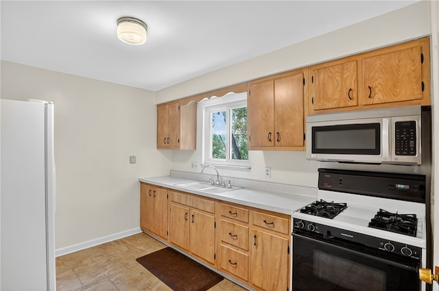 233 Ingram Ave, Ingram, PA 15205 - kitchen with stainless steel microwave, gas stove, freestanding refrigerator, and light countertops
